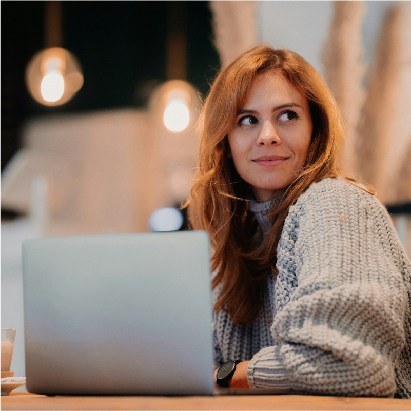 Woman smiling Infront of a laptop