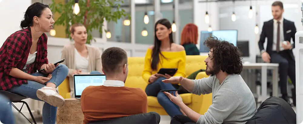 A group of modern workers in casual clothing meet in relaxed office environment