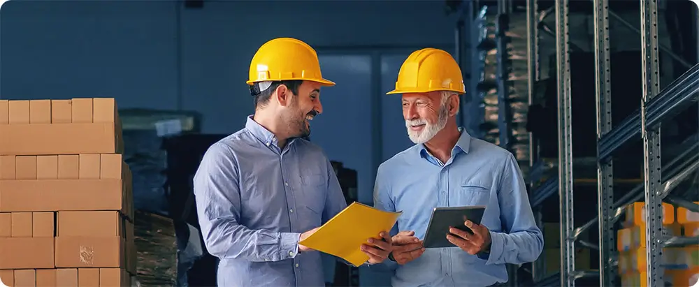 Two male builders look at tablet on building site