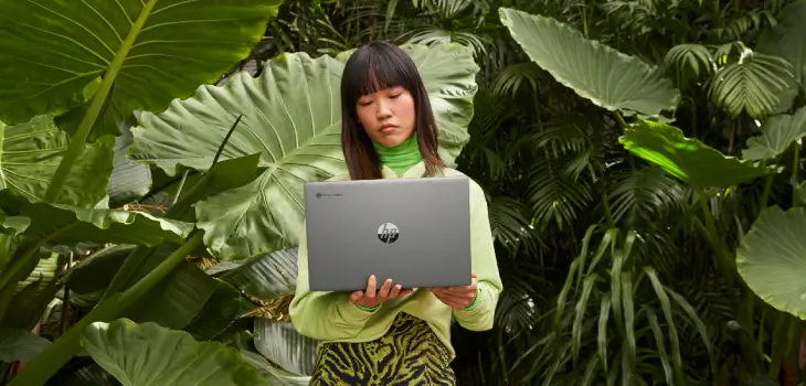 An employee holding an HP laptop